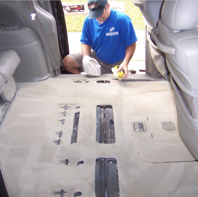 man cleaning vehicle carpet